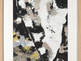 un tableau abstrait en noir et blanc, encadré de bois, accroché au mur