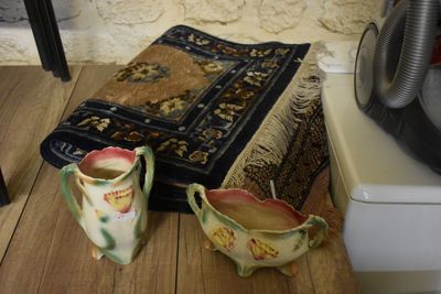 two vases sitting on a wooden table next to a rug