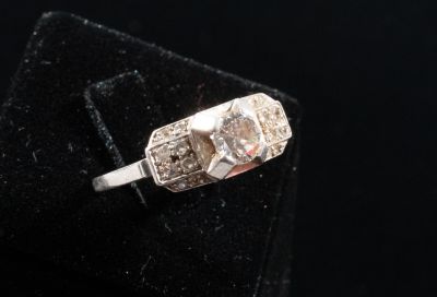 a close up of a diamond ring on a velvet surface