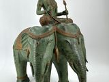 a statue of a man riding an elephant next to an orange