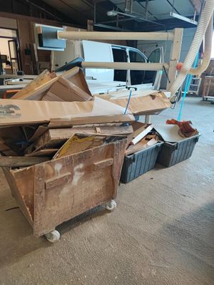 un gros tas de bois posé sur une charrette dans une pièce