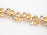 a close up of a bracelet with yellow and white stones