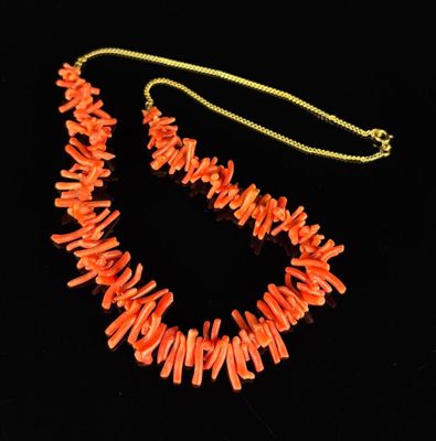 Collier orné de brins de corail, la chaîne en métal doré.
