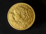 a close up of a gold coin on a black surface