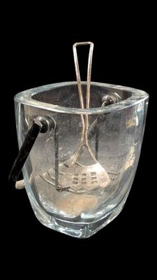 un bol en verre contenant une cuillère, sur fond noir