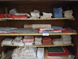 a wooden cabinet filled with lots of folded items