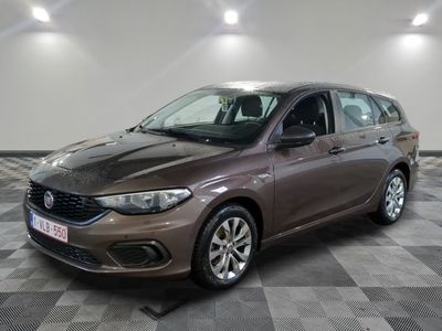 La voiture marron est garée sur un sol en carrelage à damier.