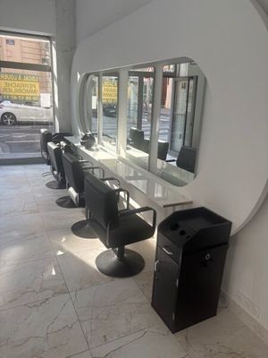 une photo d'un salon avec de nombreux fauteuils et miroirs