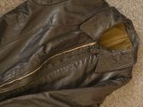 a brown leather jacket with a zipper on the inside