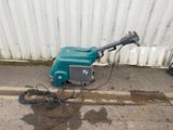 a green and black machine that is sitting on the side of the street