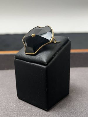 une bague noire et dorée posée sur un coffret noir