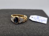 a close up of a gold ring with a blue stone on it