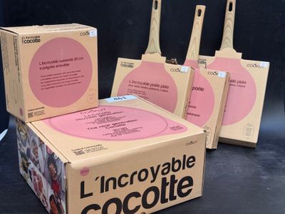 Trois boîtes de chocolats sont posées sur une table devant un fond noir.