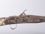 un gros plan d'un fusil avec une crosse en bois