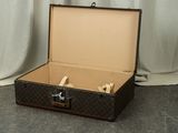 a suitcase that is sitting on the floor with a white curtain behind it