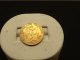 une image représentant une bague sur laquelle repose une pièce d'or