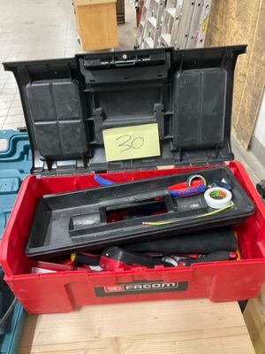 une boîte à outils rouge avec des outils sur une table