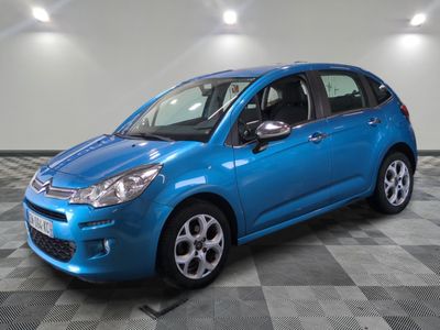 a blue car is parked in a room with a checkered floor