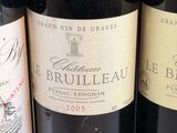 three bottles of red wine are lined up on a table