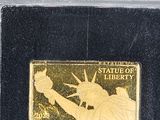 gold plated coin with the statue of liberty and the statue of liberty on it