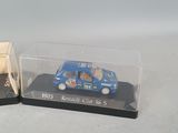 two miniature cars that are sitting in a display case