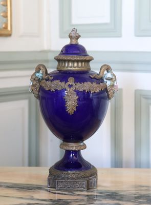 un vase violet posé sur une table en marbre dans une pièce