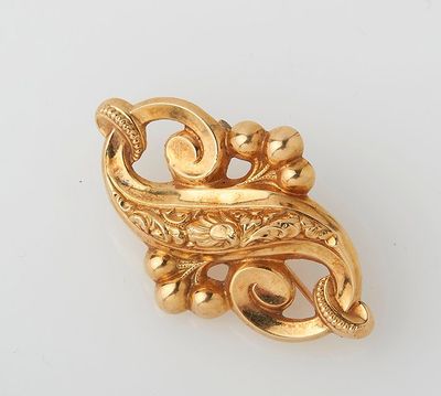 an image of a gold broochle on a white surface