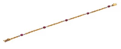 un gros plan d'un bracelet en or orné de perles rouges sur fond blanc
