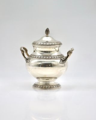 an antique silver teapot on a white surface with a white background