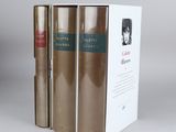 three books are stacked on top of each other on a table