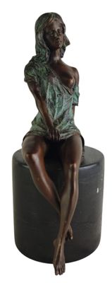 bronze statue of a woman sitting on a stool with her legs crossed