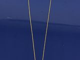 un collier en or orné d'un pendentif en perle sur un fond bleu