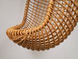 a wicker hanging chair that is hanging from the wall