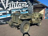 une jeep verte garée devant un immeuble