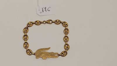 un gros plan d'un bracelet en or orné d'un alligator