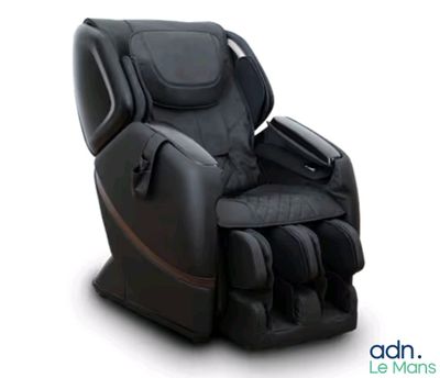 Le fauteuil de massage est noir et comporte une bande marron.