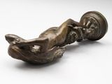 a bronze figurine of a woman laying on her stomach
