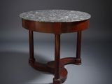 une table basse à plateau rond en marbre avec des pieds tournés