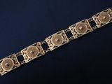 a close up of a gold bracelet on a black surface