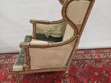 an old chair with a green cushion on top of a red rug