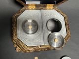 a small silver box with two silver bowls inside of it