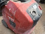 a red and black suitcase sitting on the floor in a garage