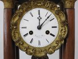 a clock that is sitting on top of a wooden stand