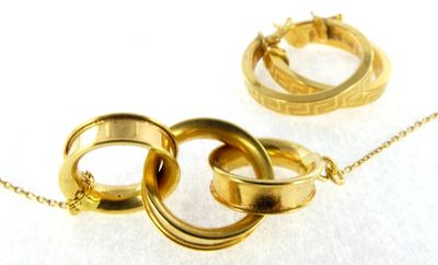 two gold rings on a gold chain on a white surface