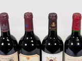 four bottles of wine are lined up on a white surface