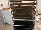 a metal rack with four trays of food on it