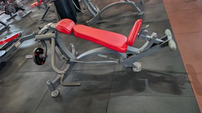 a red bench in the middle of a gym room