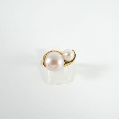 une bague en or sertie d'une perle blanche sur un fond blanc