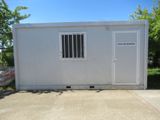 une image représentant une maison-conteneur blanche dotée d'une porte