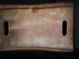une planche à découper en bois percée de trous au milieu